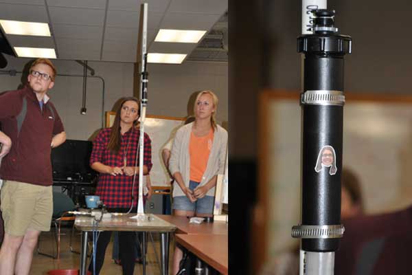 Christopher Davidson (from left), Halle Swann and Samantha Nelson watch as their device's performance is displayed on a screen during the Rapid Design Challenge. The team, which also included Jai Sahni, had the winning entry and a little inspiration from a sticker photo of senior design course instructor Angela Pannier.