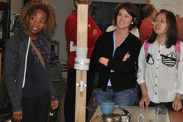 Ashley Eure, Megan Tucker and Danni Liu watch their screen as the performance of their device is displayed during the Rapid Design Challenge.