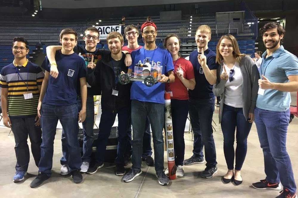 A team of College of Engineering students – (from left), Ahbab Murtoza, Alex McKinney, Austin Eidem, Bryce Puck, Eric Burbach, Julian Davis, Mary Rethwisch, Austin Osborn, Shelby Williby and Ernesto Bravo Baltodano – and its car, 