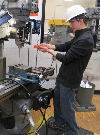 A worker using a tool to measure.