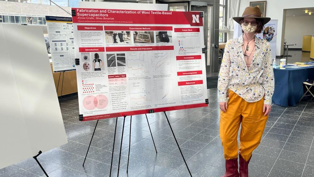 Alyssa standing with her poster about fabricating and characterizing cotton and wool textile based supercapacitors. 