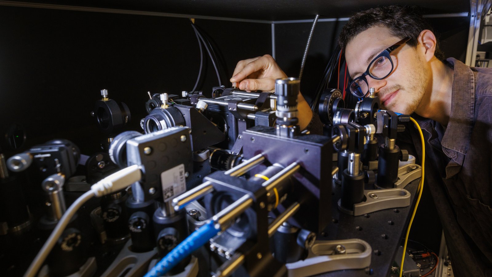 Doctoral student Adam Erickson adjusts the nitrogen-vacancy scanning probe in Abdelghani Laraoui's lab. (Craig Chandler / University Communication and Marketing)