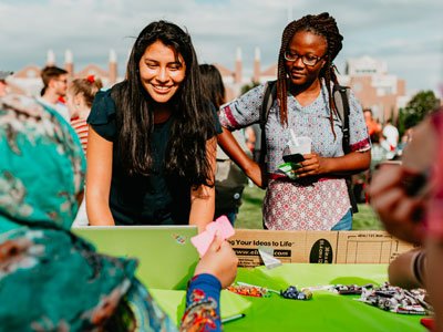 Two women look at a booth during the annual Rock the Block event.