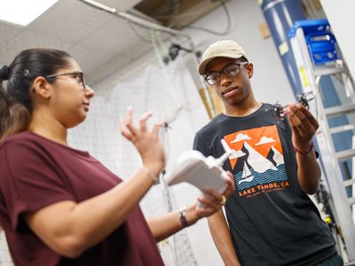 Two students work with a drone in the NIMBUS Lab